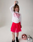 Model wearing Chaser's Merry Girls Long Sleeve Tee in white with holiday lettering, editorial view