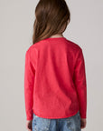 Model wearing Chaser's Howdy Holidays Girls Long Sleeve Tee in hibiscus with western holiday graphic, back view