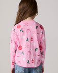 Model wearing Chaser's Yummy Holidays Girls Long Sleeve Tee in camelia pink with holiday treat print, back view