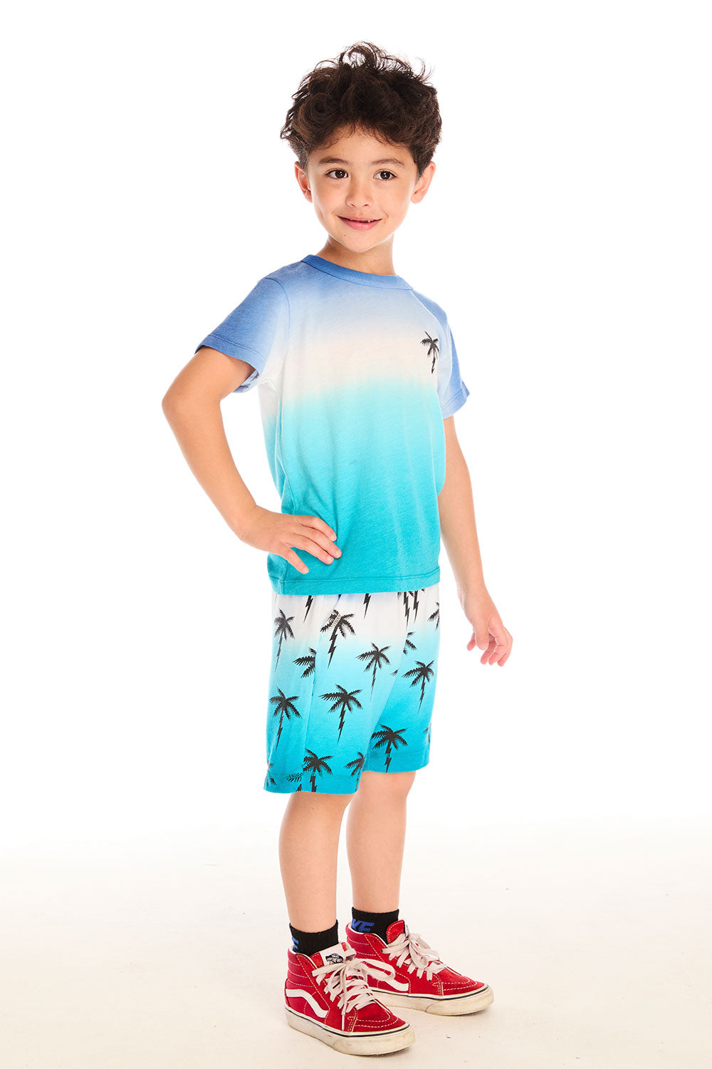 Boy wearing Chaser Kids Lightning Palm Tee paired with Lightning Palms Shorts, full body view on white background