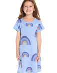 Girl wearing the Chaser Kids Allover Rainbows Short Sleeve Shirt Dress in Blue Hydrangea with colorful rainbow graphics on a white background