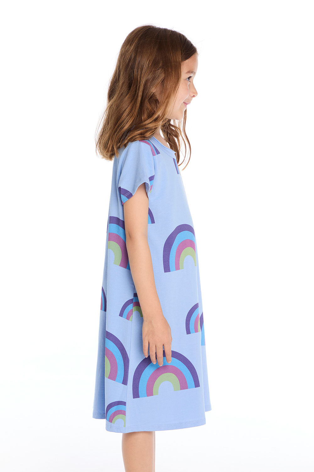 Side view of the Chaser Kids Allover Rainbows Short Sleeve Shirt Dress in Blue Hydrangea featuring colorful rainbow graphics on a white background