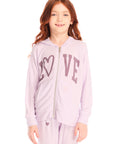 Girl wearing Chaser’s light pink Love Zip Up Hoodie with ‘LOVE’ printed on it against a white background