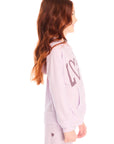 Side view of girl wearing Chaser’s light pink Love Zip Up Hoodie with ‘LOVE’ print against a white background