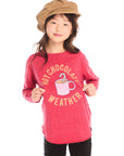 Girl wearing Chaser’s red Hot Chocolate Weather Long Sleeve with a graphic design, black pants, and a brown hat on a white background