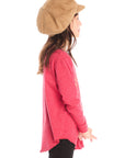Side view of girl wearing Chaser’s red Hot Chocolate Weather Long Sleeve with a graphic design and black pants on a white background