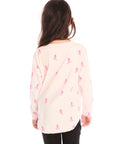 Back view of young girl wearing Chaser’s light pink Allover Pink Skiers long sleeve top with skier patterns on a white background