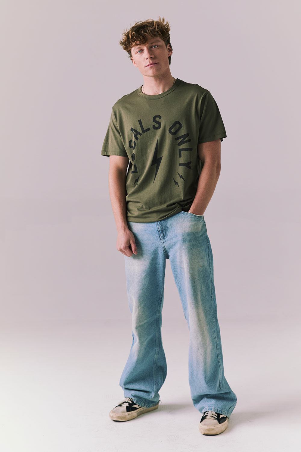 Full body of model wearing Locals Only tee in Backwoods Green.