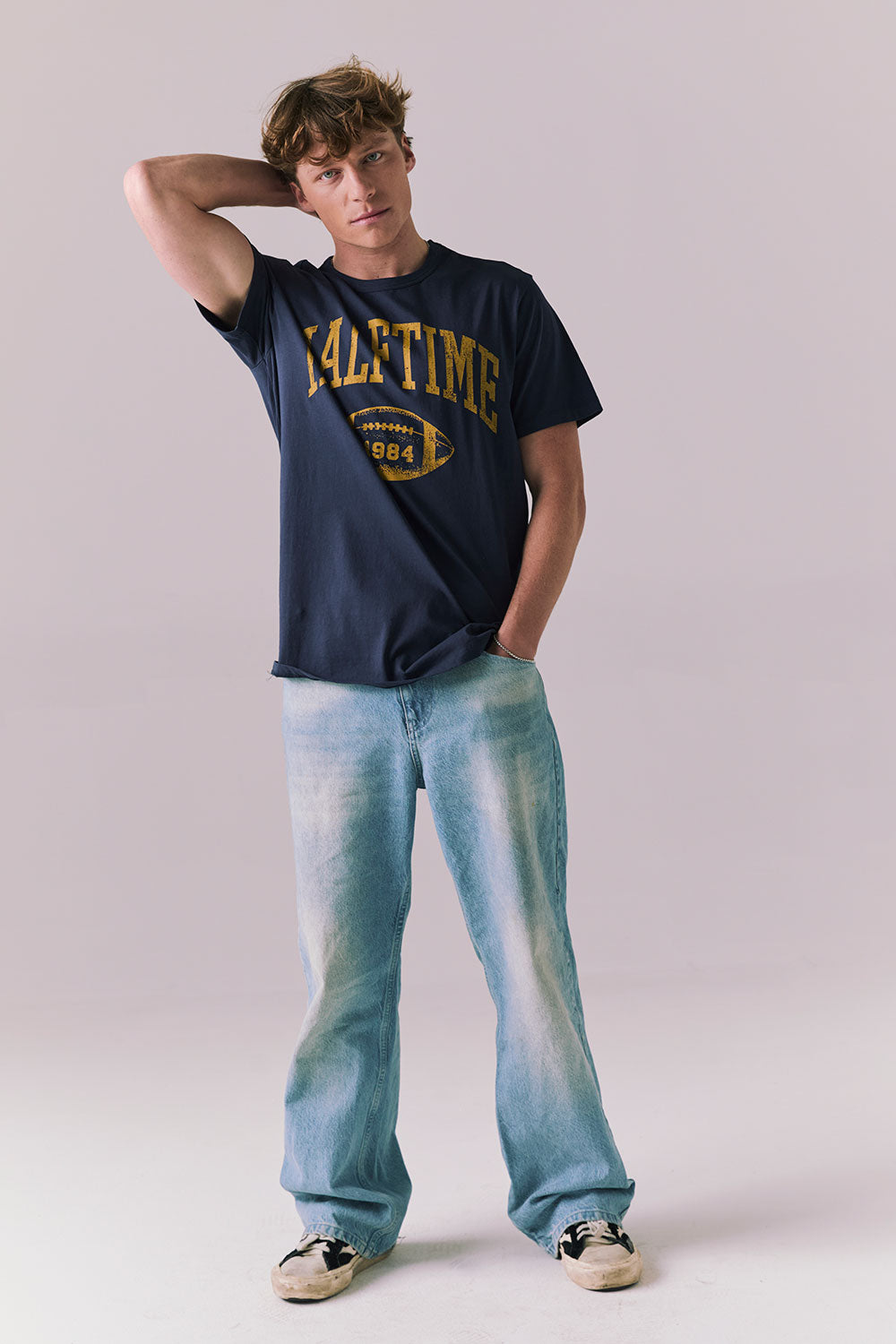Full body view of model wearing navy Halftime 1984 tee.