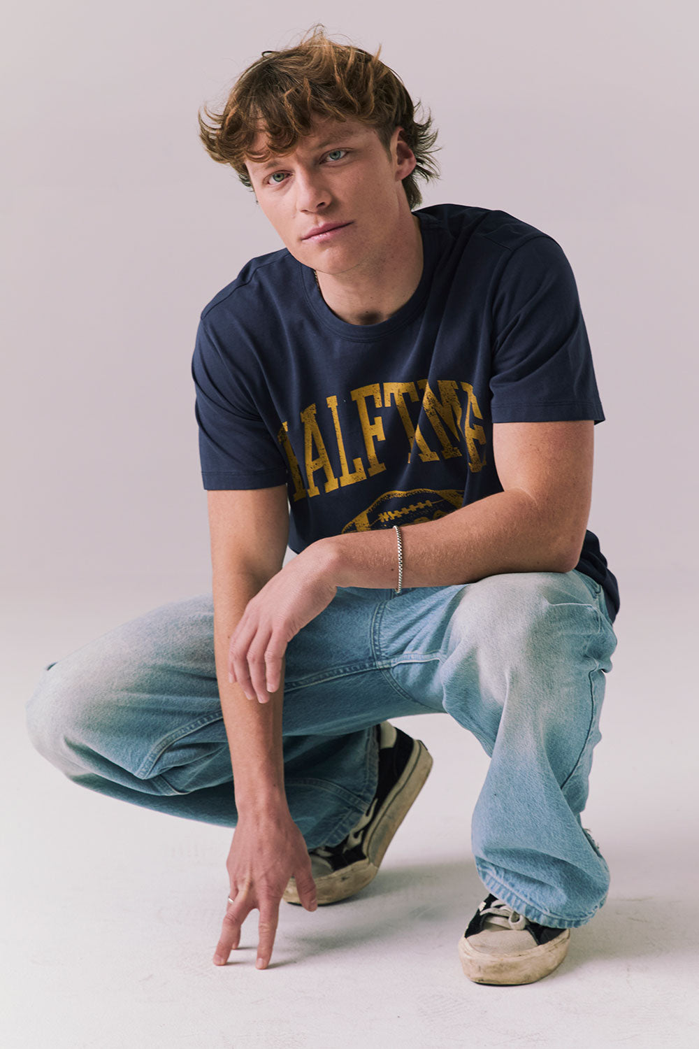 Full body view of model wearing navy Halftime 1984 tee.
