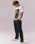 Side full body view of model in Elvis graphic tee in white.