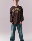 Full body of model in Kahlua Brown New York 1975 long sleeve tee.