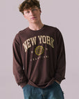 Front view of New York 1975 long sleeve tee in Kahlua Brown with cityscape graphic.
