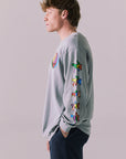 Side view of silver grey graphic long sleeve featuring vibrant skull sleeve detail.