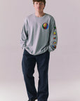 Full body view of model wearing Grateful Dead silver grey rainbow skull graphic long sleeve.
