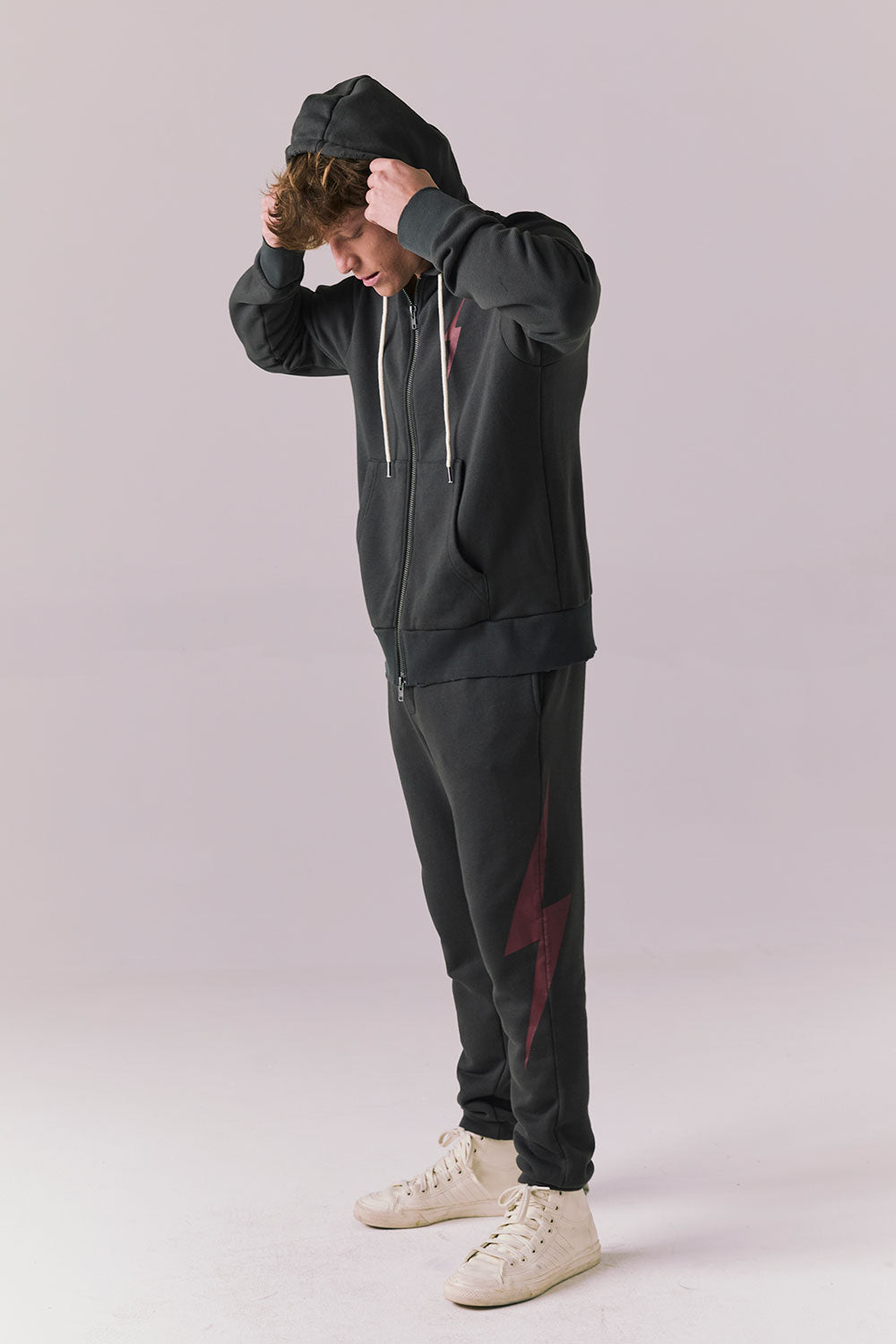 Side full body of model in Bolt Black Hoodie and pants set.