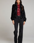 Full body view of woman wearing Chaser’s Puff Sleeve Licorice Jacket styled with a red sequin top and black pants on a plain background