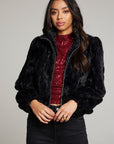 Front view of woman wearing Chaser’s Puff Sleeve Licorice Jacket over a red sequin top, paired with black pants on a plain background
