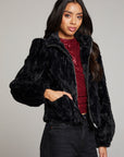Side view of woman wearing Chaser’s Puff Sleeve Licorice Jacket with subtle puff sleeve detail over a red sequin top on a plain background