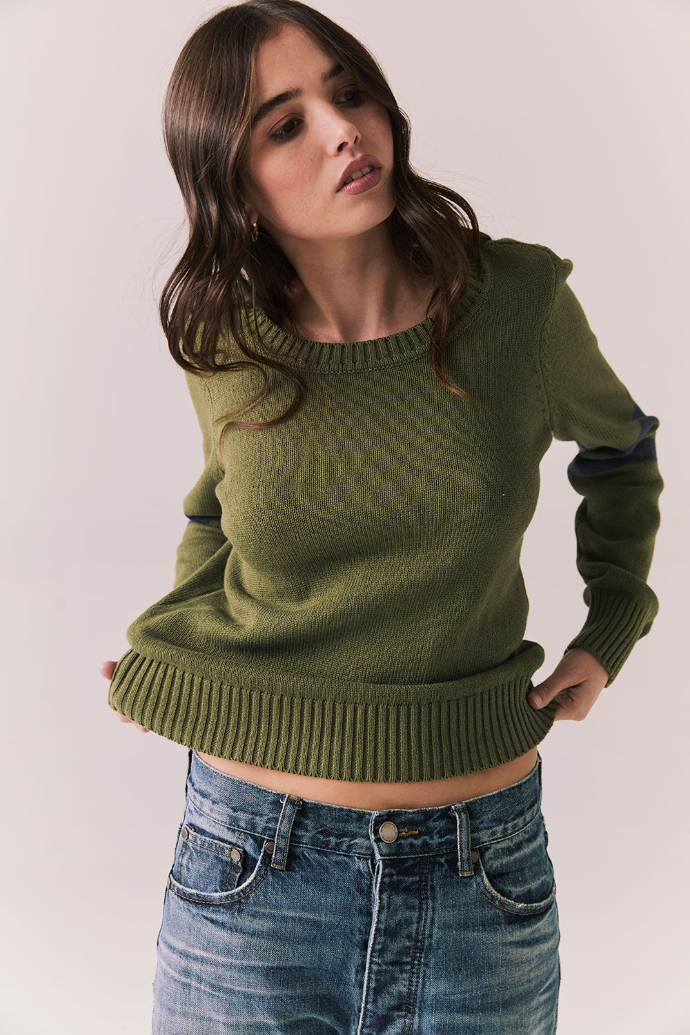 Front view of Varsity Star Sweater in bronze green with slouchy fit and twin arm stripes against a plain background