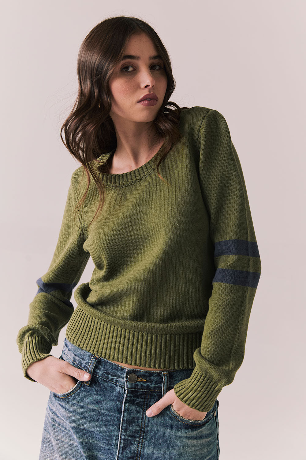 Front view of Varsity Star Sweater in bronze green with slouchy fit and twin arm stripes against a plain background