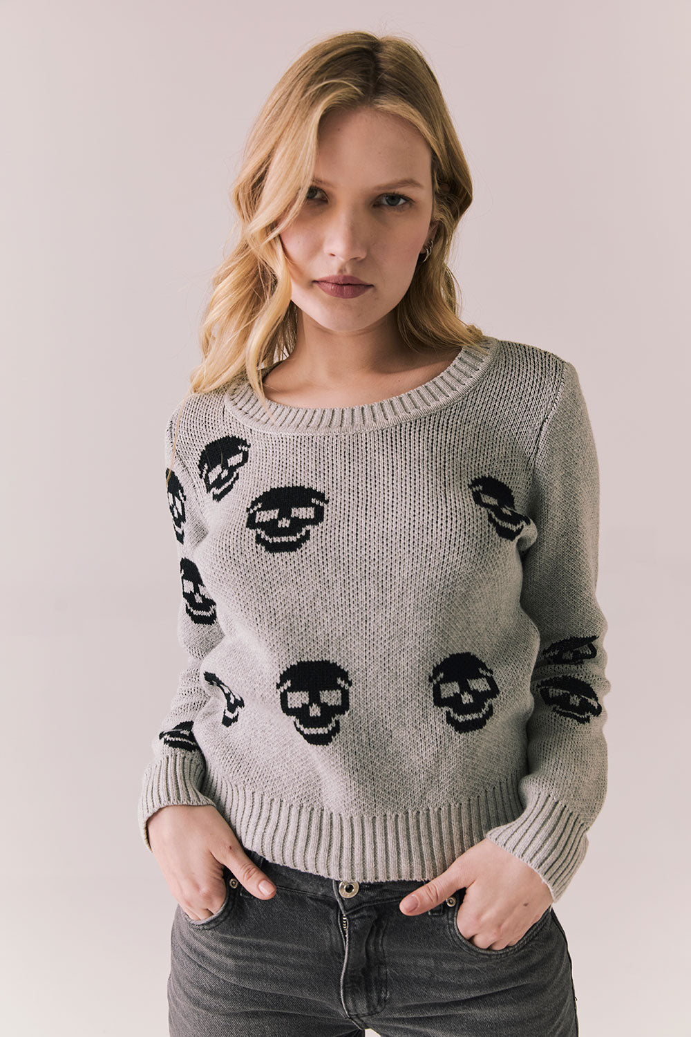 Front view of Tossed Skulls Long Sleeve sweater in Heather Grey with allover black skull motif and fitted silhouette against a plain background