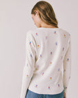 Back view of woman wearing Chaser's Allover Skiers with small colorful patterns and blue jeans on a light gray background