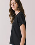 Side view of woman wearing Chaser’s black Tini Time Tee on a plain background