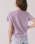Back view of woman wearing Chaser’s The Rolling Stones ’78 Tour Amethyst Purple Tee on a plain background