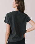 Back view of woman wearing Chaser’s Tom Petty Live At The Fillmore Tee on a plain background