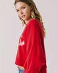 Side view of woman wearing Chaser's red Apres Ski Cheers with graphic design on a plain background