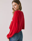 Back view of woman wearing Chaser's red Apres Ski Cheers with graphic design on a plain background