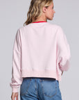 Model wearing Chaser's Champagne Party Pullover in Pinky pink with festive champagne glass artwork, back view