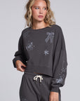 Model wearing Chaser's Holiday Cheer Pullover in Fresh Gravel with scattered holiday icons, front view