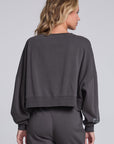 Model wearing Chaser's Holiday Cheer Pullover in Fresh Gravel with scattered holiday icons, back view