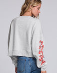 Model wearing Chaser's Rolling Stones Tattoo You Pullover in Heather Grey with colorful Rolling Stones Tattoo You artwork and red sleeve graphics, back view