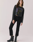 Woman wearing Chaser's black oversized Black Sabbath Vol 4 Long Sleeve top with a graphic design, black pants, and black boots on a white background