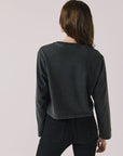 Back view of woman wearing Chaser's black oversized Black Sabbath Vol 4 Long Sleeve top with black pants on a white background