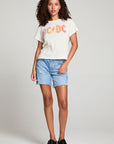 Full body view of model in AC/DC 1979 Tour Gradient Tee styled with denim shorts for a retro festival look against a plain background