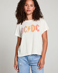 Front view of model in AC/DC 1979 Tour Gradient Tee styled with denim shorts for a retro festival look against a plain background