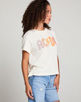 Side view of model in AC/DC 1979 Tour Gradient Tee styled with denim shorts for a retro festival look against a plain background