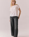 Full front view of model wearing the Tossed Bolts short sleeve tee in white with black scattered lightning bolt graphic and relaxed fit and gray pants on a plain background