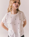 Front view of Tossed Bolts short sleeve tee in white with scattered black lightning bolt graphic and relaxed fit against a plain background