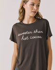 Front view of woman wearing Chaser’s brown Hot Cocoa Tee with “sweeter than hot cocoa” text on a plain background
