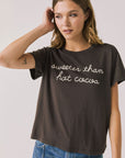Front view of woman wearing Chaser’s brown Hot Cocoa Tee with “sweeter than hot cocoa” text on a plain background