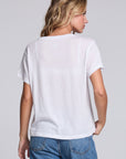 Model wearing Chaser's Oh What Fun Tee in White with pastel Oh What Fun holiday lettering, back view