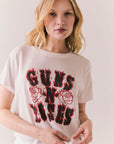 White graphic tee with flaming Guns N’ Roses logo and floral artwork.