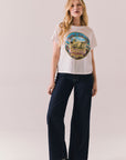 Full body of model wearing Tom Petty tee styled with ripped jeans.