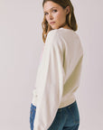 Back view of woman wearing Chaser’s The Beatles Come Together Starry White Long Sleeve on a plain background