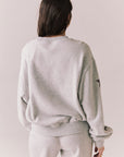 Back view of NYC Stars Pullover in Heather Grey with bold chest lettering and black star sleeves against a plain background